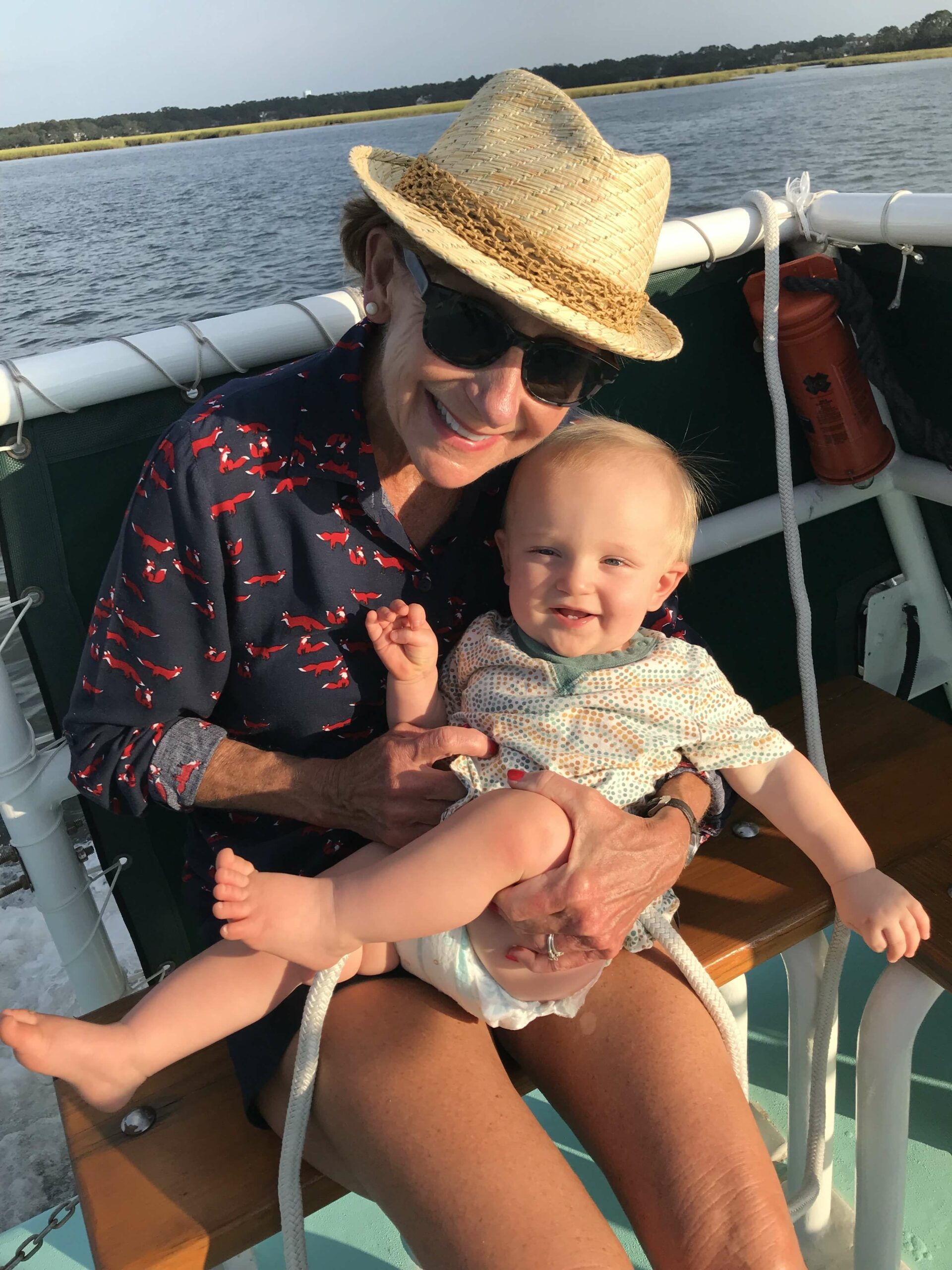 woman holding a baby on a ship on sunset cruise